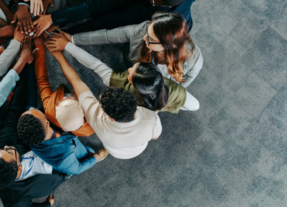 Colleagues putting their hands together in the middle
