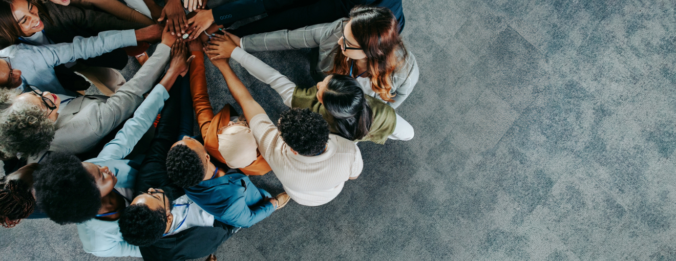 Colleagues putting their hands together in the middle