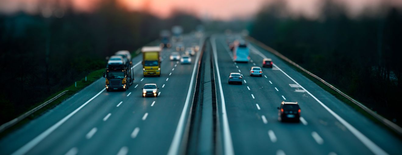 Vehicles travelling on a multi‑lane motorway at dusk