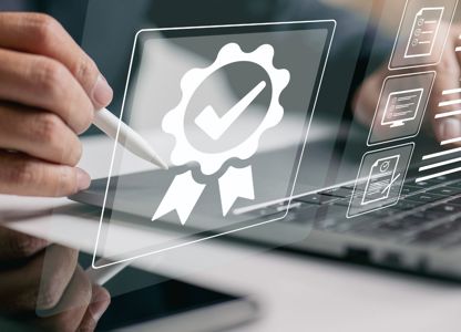 Person using a stylus on a tablet next to a laptop, with digital certification and checklist icons overlayed on the screen