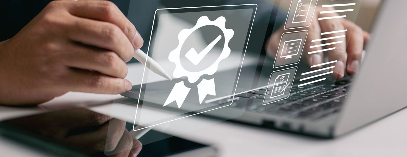 Person using a stylus on a tablet next to a laptop, with digital certification and checklist icons overlayed on the screen