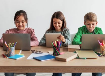 School children in a classroom using digital devices