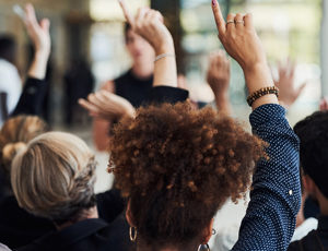 A group of employees with their hands raised