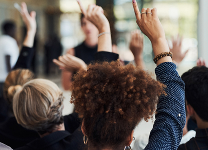 A group of employees with their hands raised
