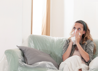 A person sat on the sofa with black mould